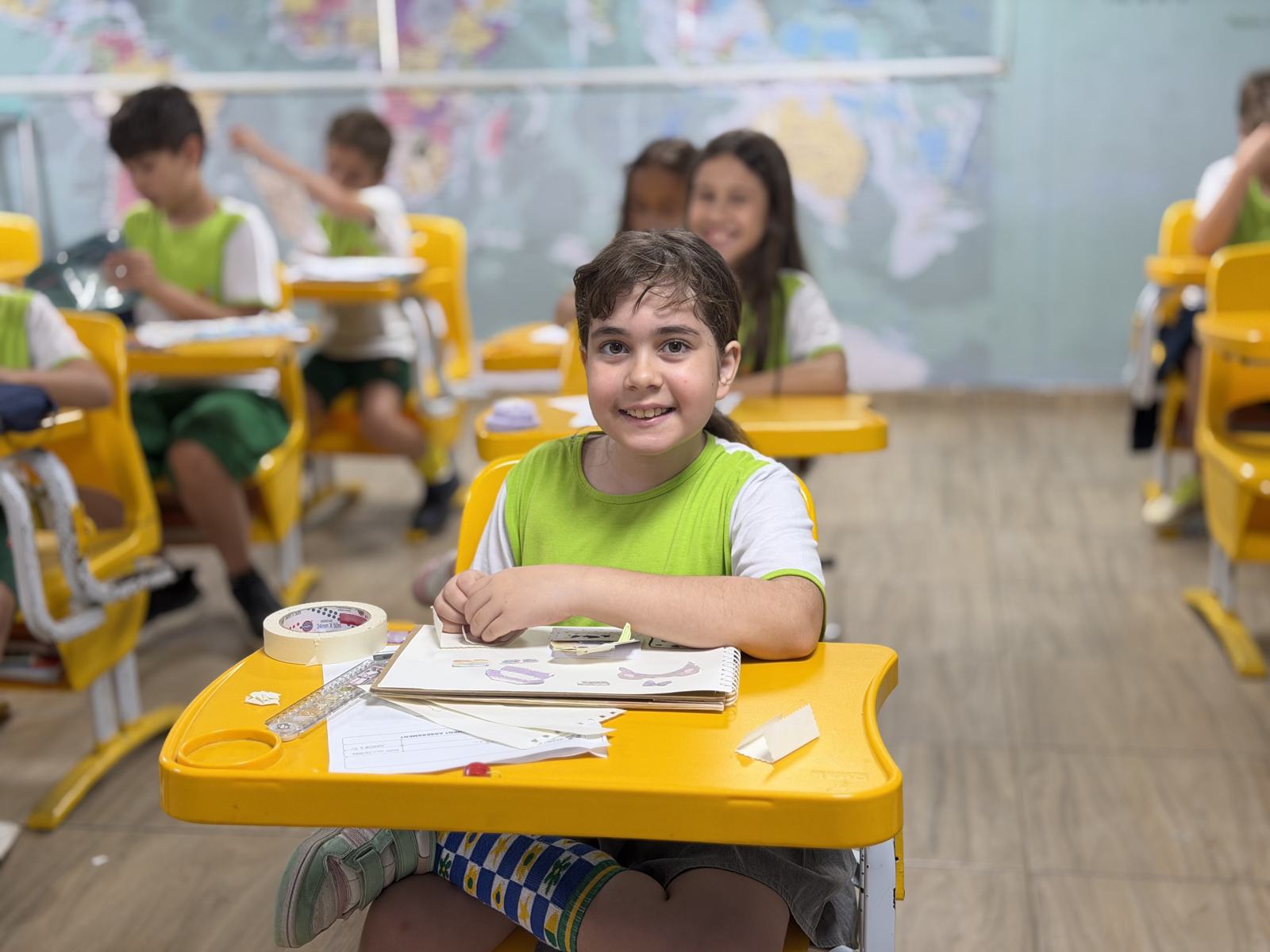 Aluno do Elementary sorrindo na carteira