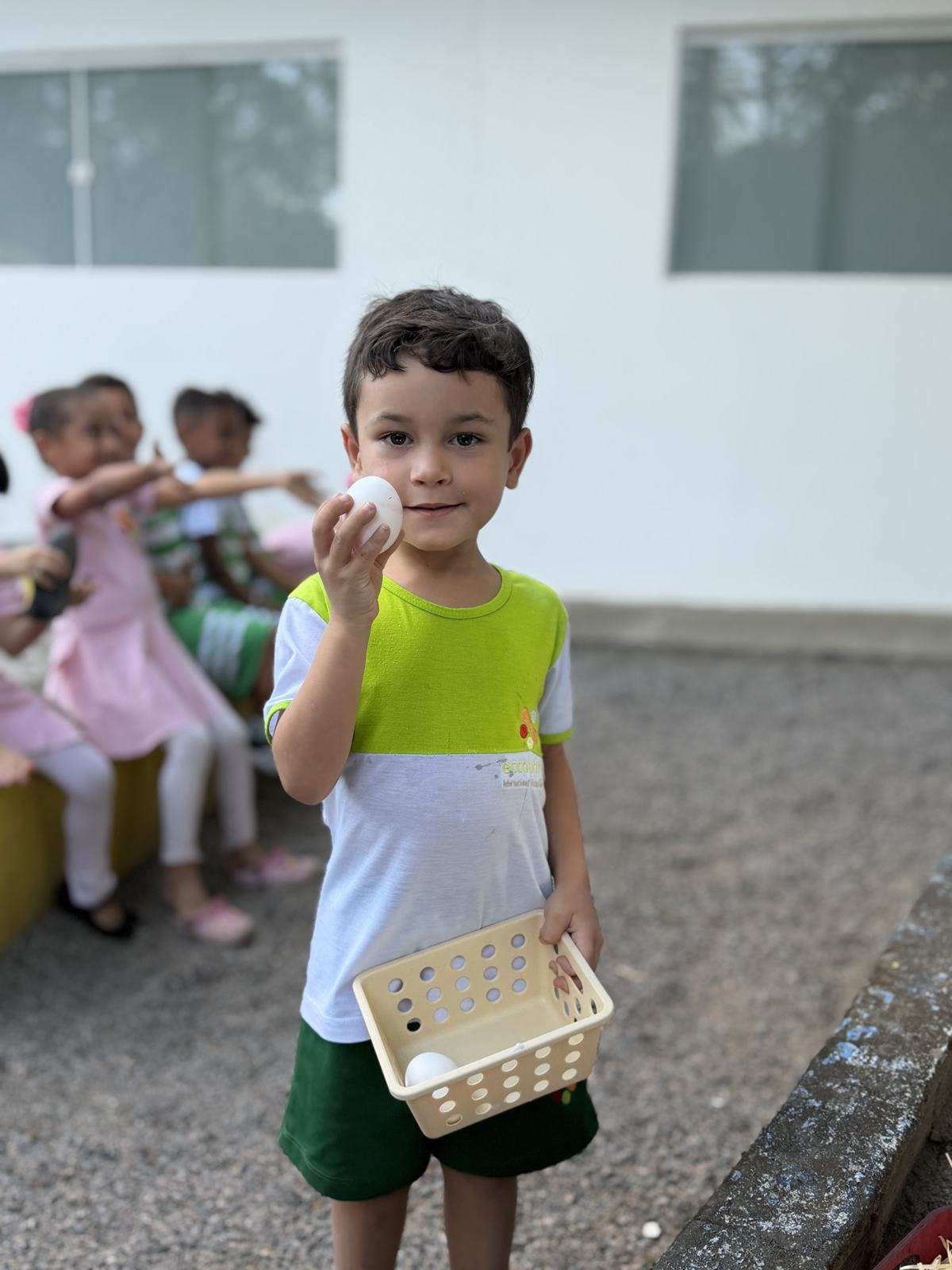 Aluno do Kindergarten segurando uma cesta